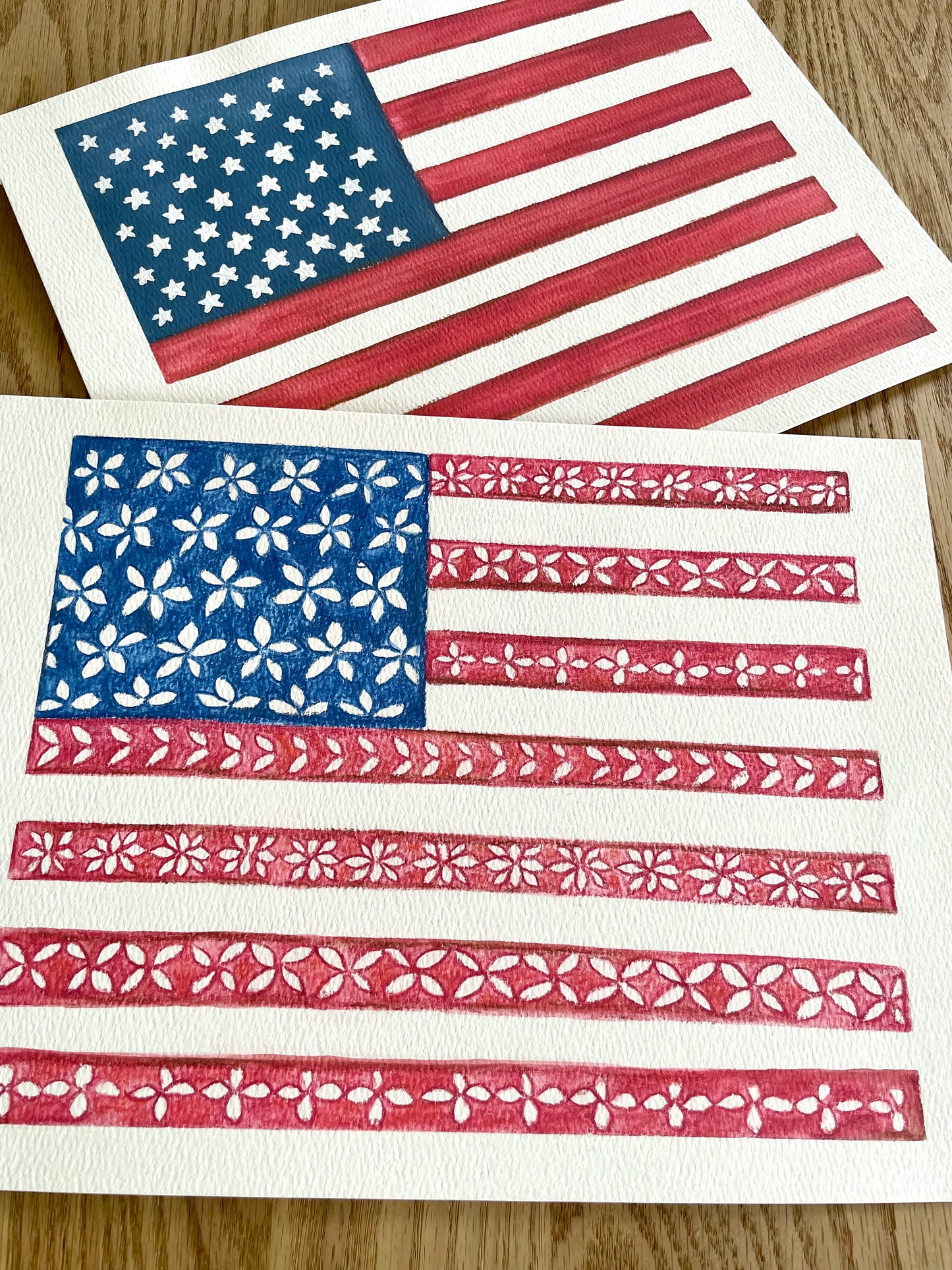 Two American flags with floral patterns on a wooden surface