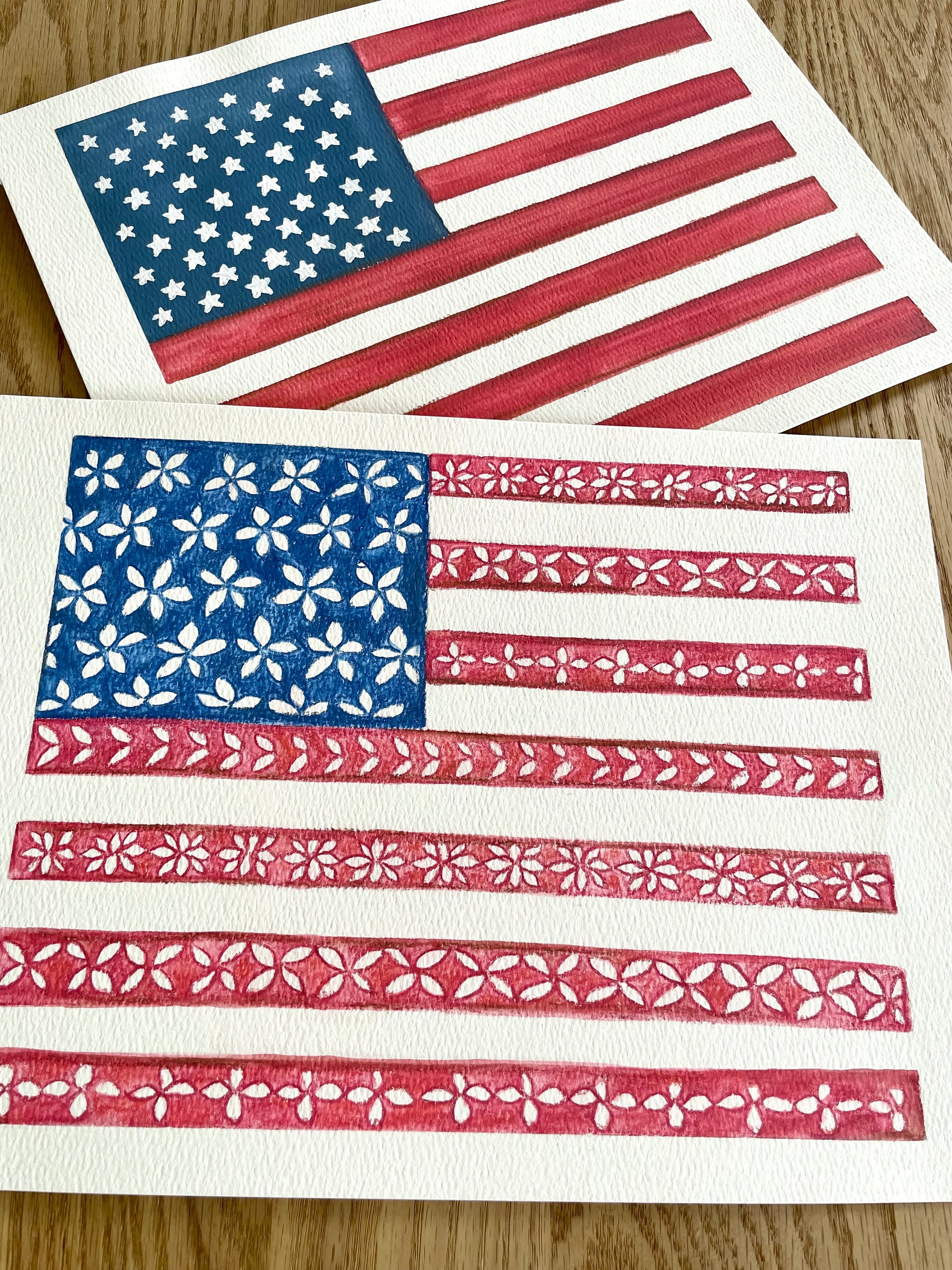 Two American flags with floral patterns on a wooden surface