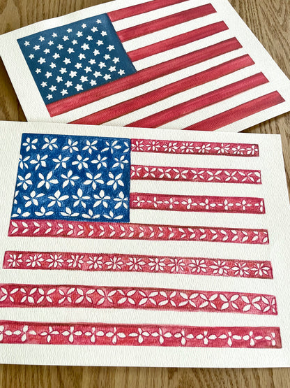 Two American flags with floral patterns on a wooden surface