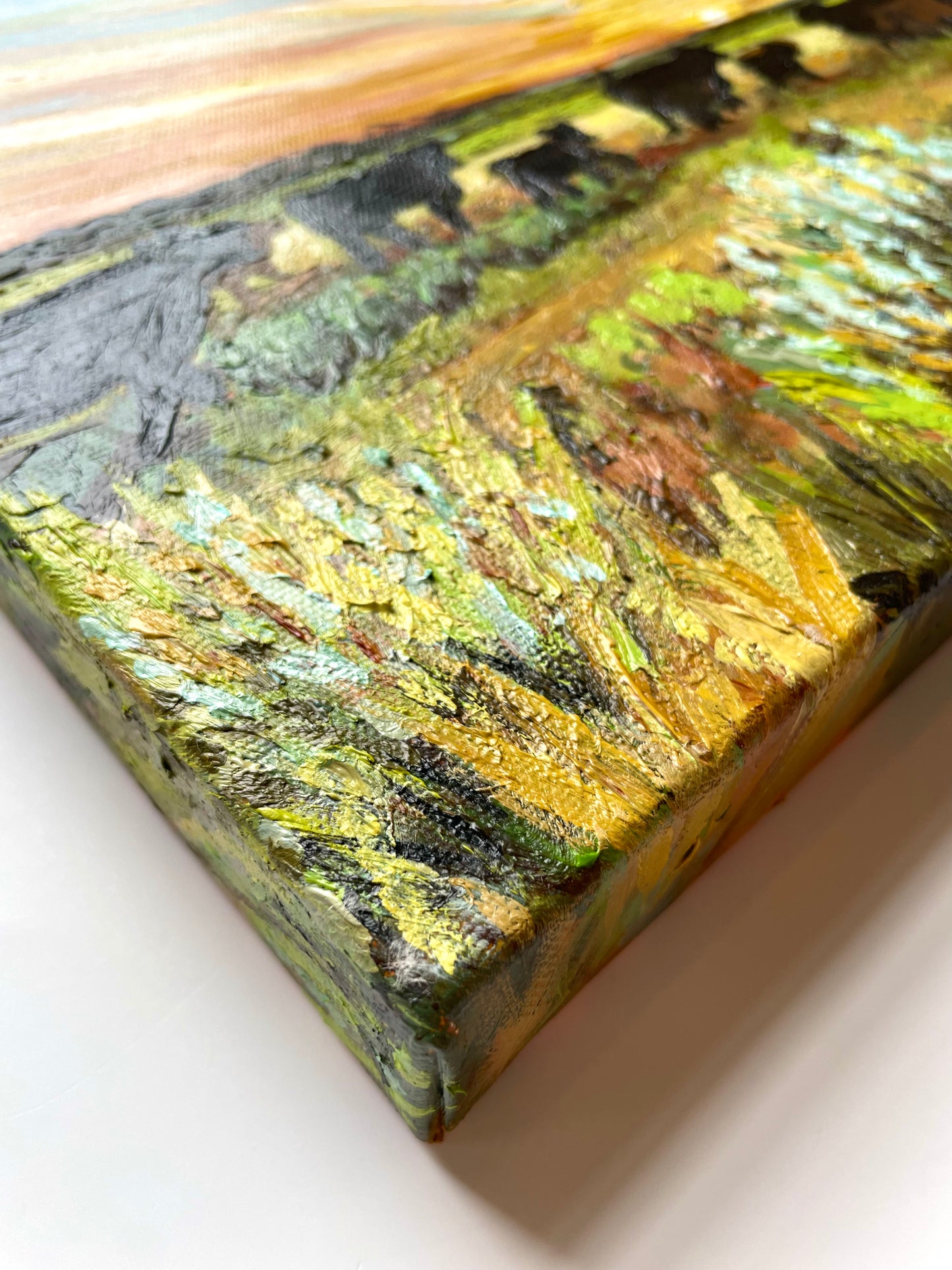 Close-up of a textured painting with green, brown, yellow and black colors 