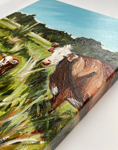Canvas painting of a cow in a field with a tree-filled background