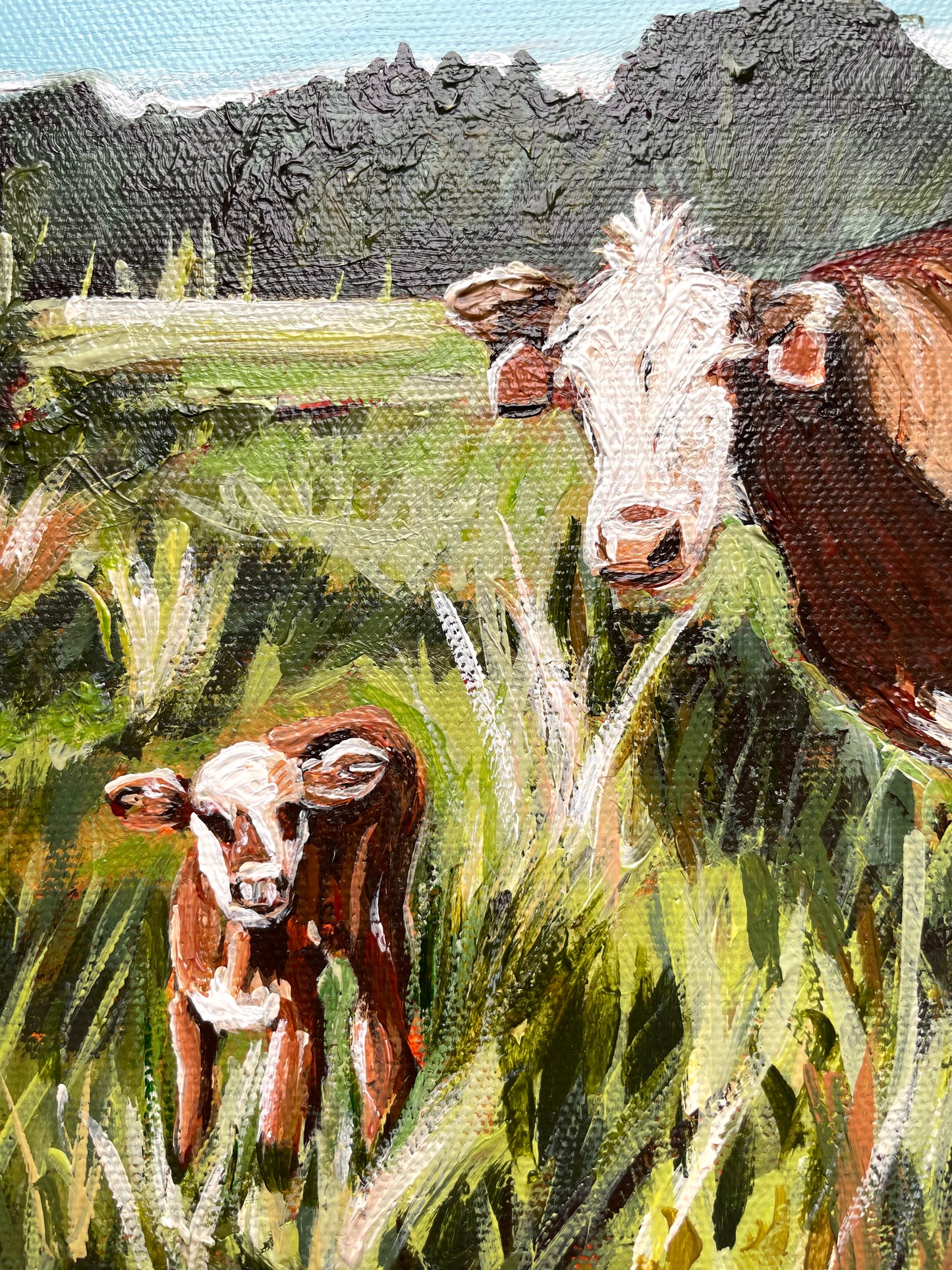 Painting of two cows in a grassy field with a tree line background