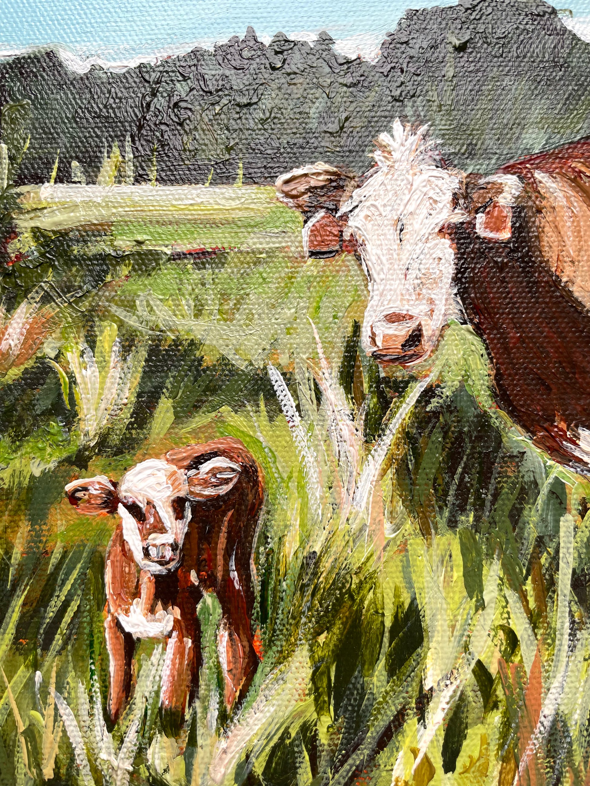 Painting of two cows in a grassy field with a tree line background