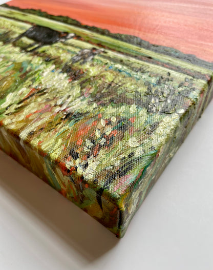 Close-up of a textured painting on a canvas with a landscape scene